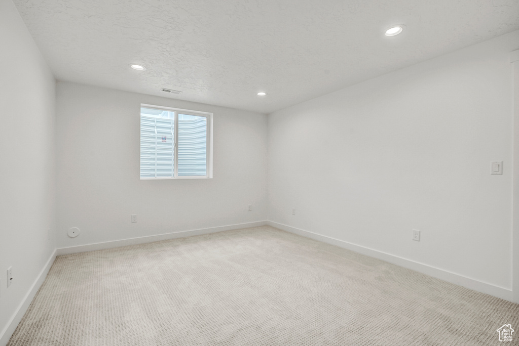 Unfurnished room with light carpet, baseboards, and recessed lighting