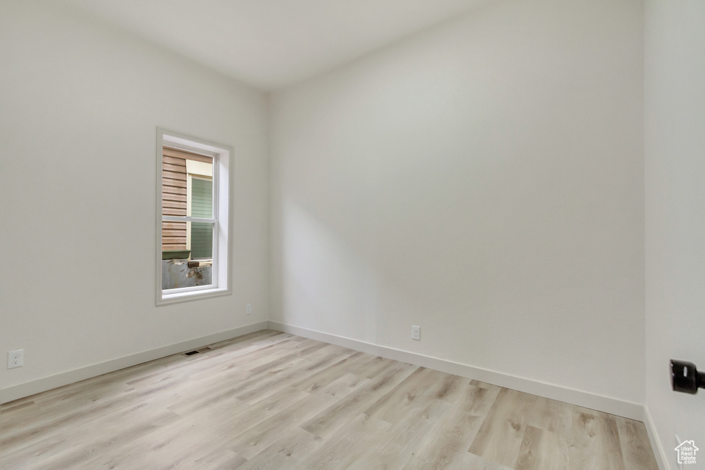 Spare room with light wood-type flooring and baseboards
