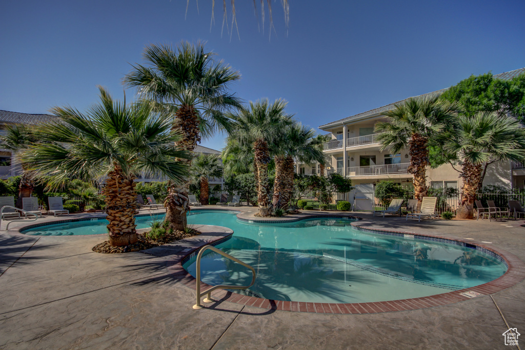 Community pool featuring a patio and fence
