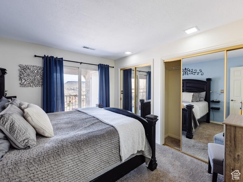 Carpeted bedroom with two closets and baseboards