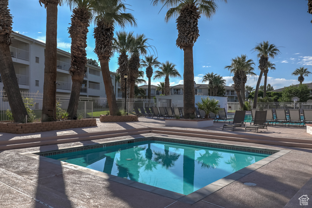 View of pool with a patio area, fence, and a residential view