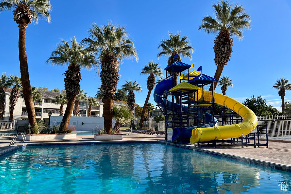 Community pool with fence and a water slide