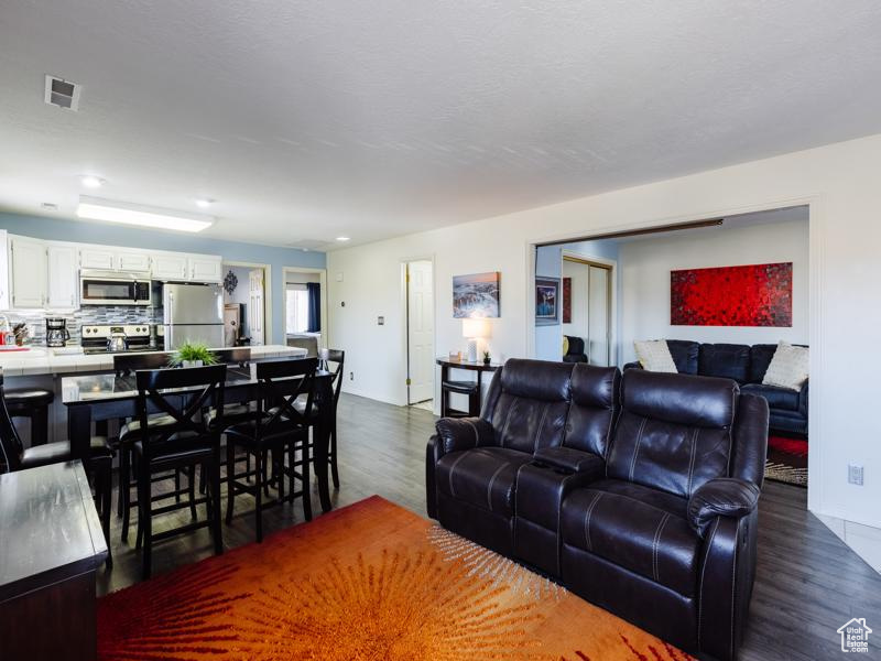 Living room with dark wood finished floors and recessed lighting