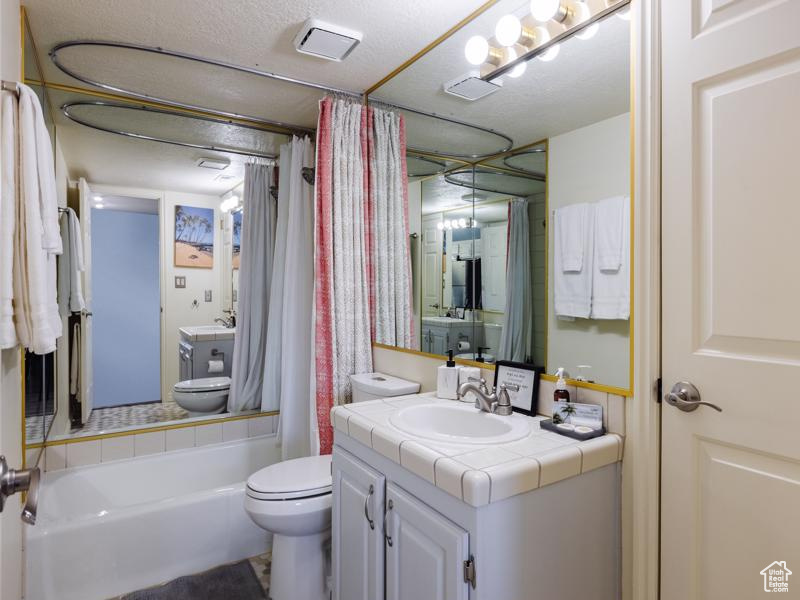 Bathroom with toilet, vanity, and shower / tub combo