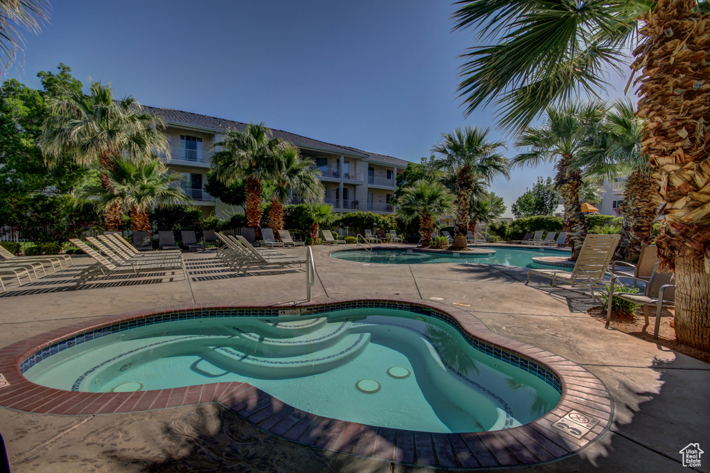 Community pool featuring a hot tub and a patio area