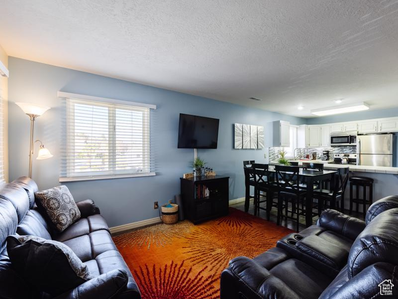 Living area with baseboards and a textured ceiling