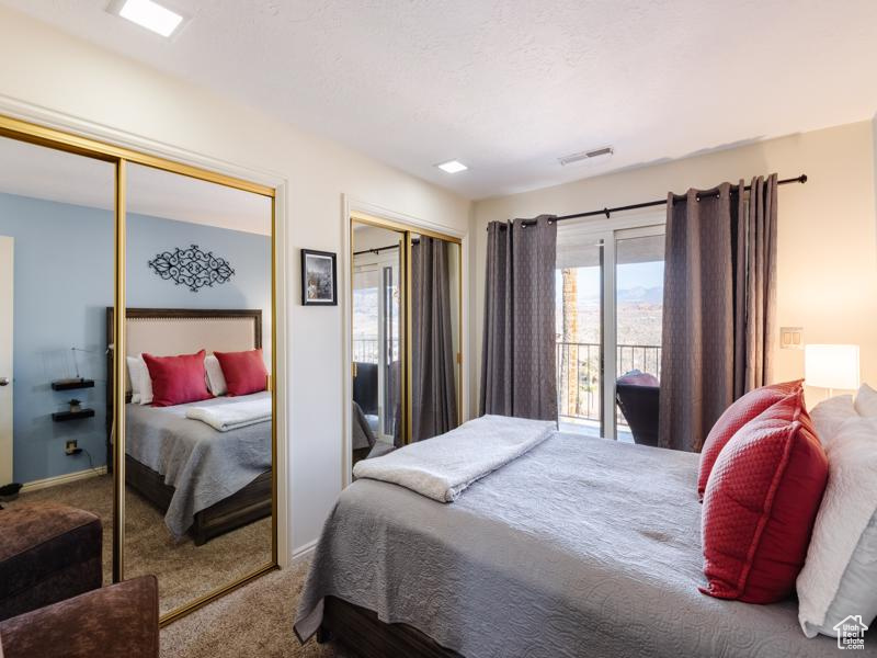 Bedroom with carpet, multiple closets, and baseboards