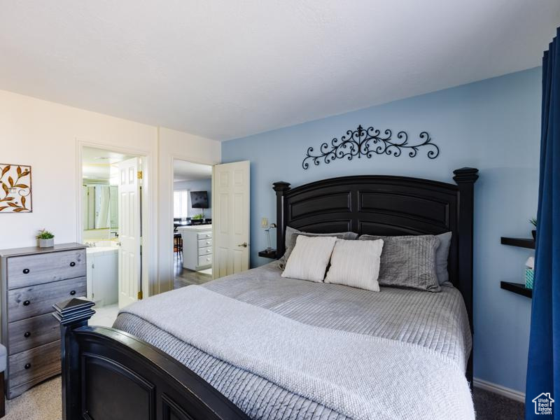 Bedroom with light colored carpet and connected bathroom