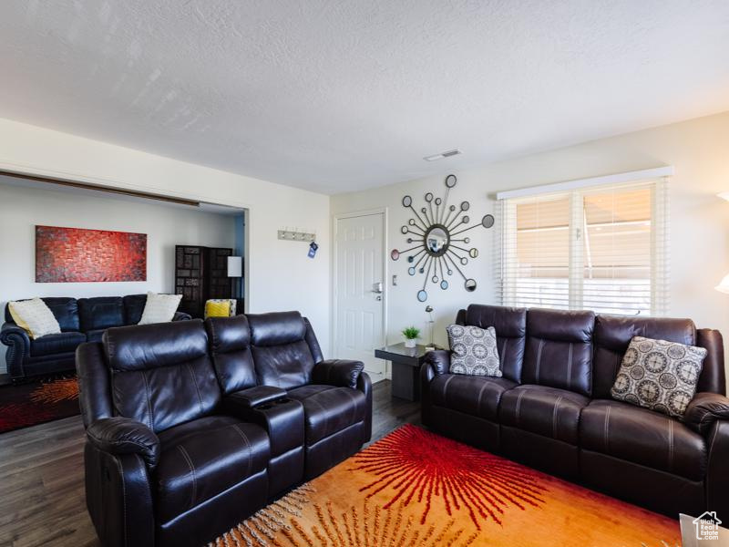 Living area featuring wood finished floors and a textured ceiling