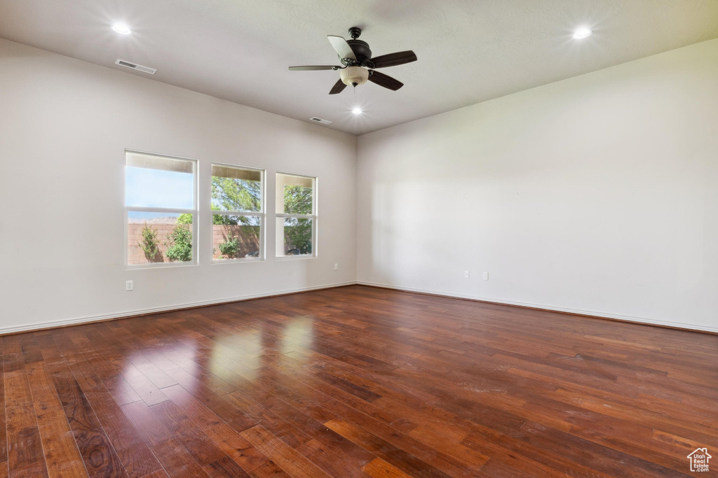 Empty room featuring hardwood / wood-style flooring, a ceiling fan, recessed lighting, and baseboards