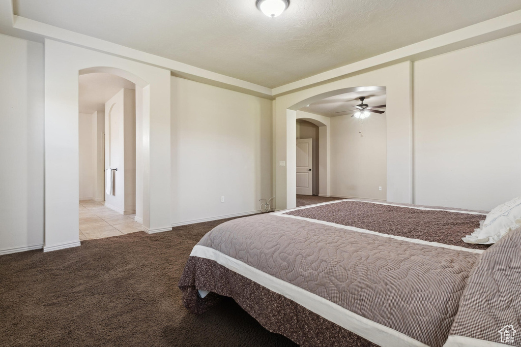 Carpeted bedroom with arched walkways and baseboards