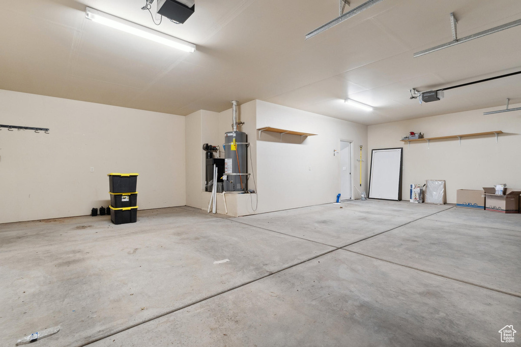 Garage featuring secured water heater and a garage door opener