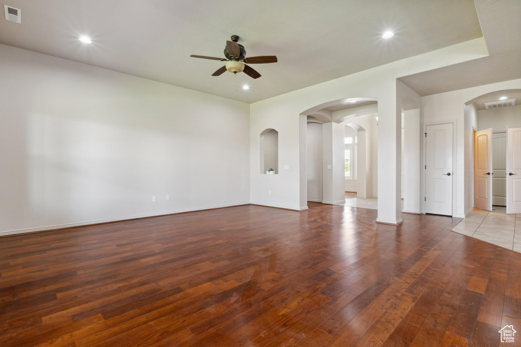 Spare room featuring a ceiling fan, arched walkways, wood finished floors, and recessed lighting