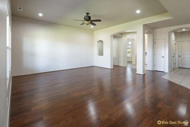 Spare room with ceiling fan, arched walkways, wood finished floors, and recessed lighting