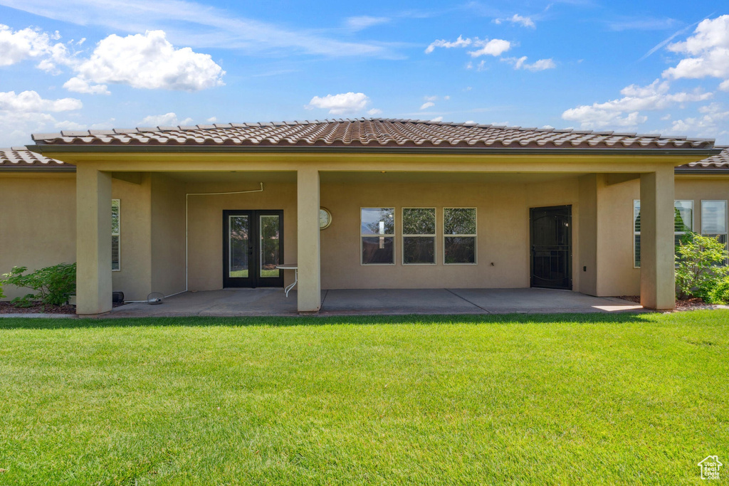Back of house featuring stucco siding, french doors, a patio area, a tiled roof, and a yard