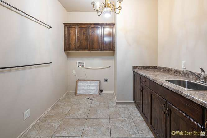 Laundry room featuring cabinet space, washer hookup, a chandelier, electric dryer hookup, and light tile patterned floors