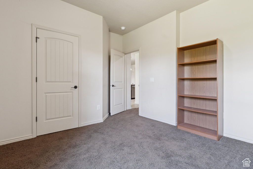 Unfurnished bedroom with carpet flooring and baseboards