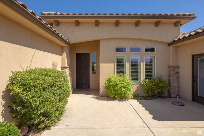 Entrance to property with a patio area and stucco siding