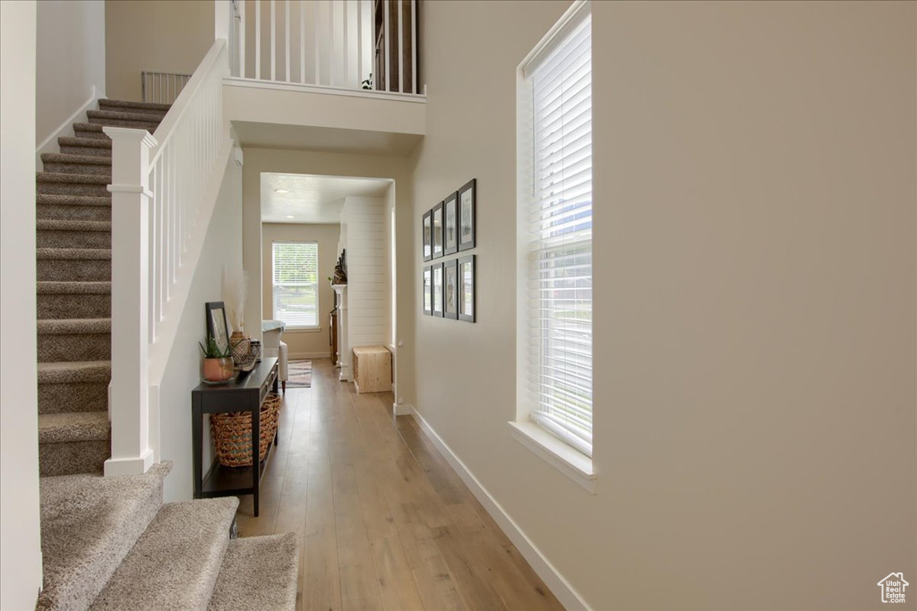 Foyer with stairs, light wood-style floors, and baseboards