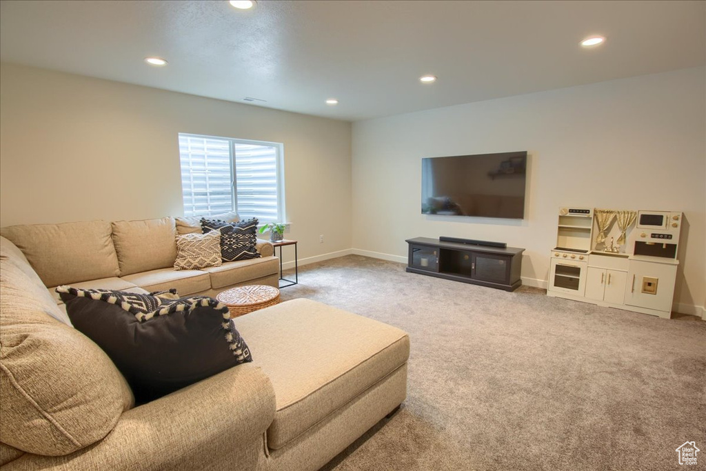 Carpeted living room featuring recessed lighting and baseboards