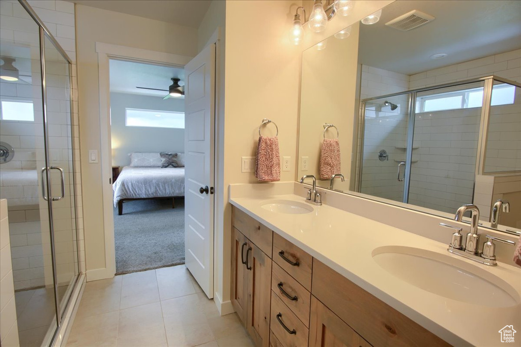 Bathroom with double vanity, connected bathroom, a shower stall, and tile patterned floors