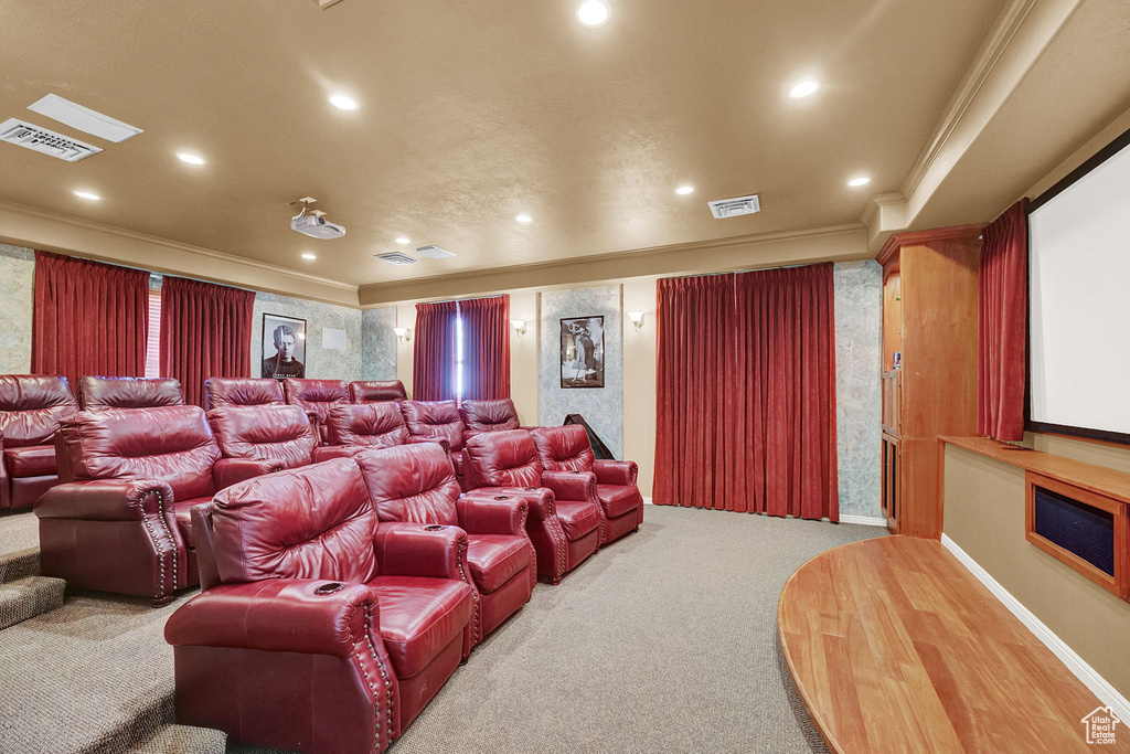 Home theater room featuring carpet floors, crown molding, recessed lighting, and baseboards