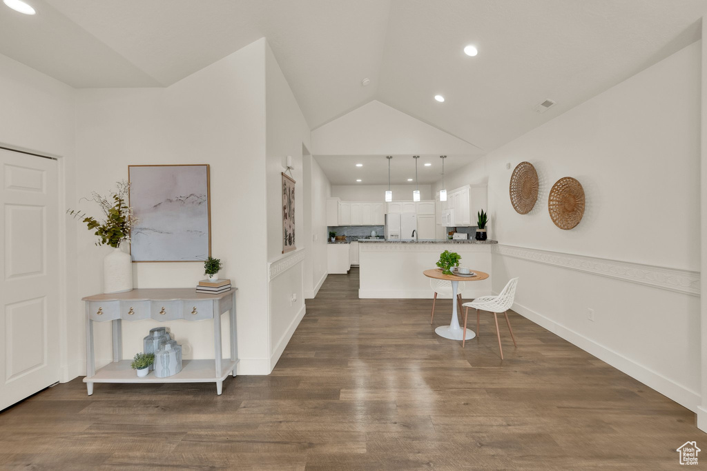 Foyer with vaulted ceiling, dark wood-style floors, and recessed lighting