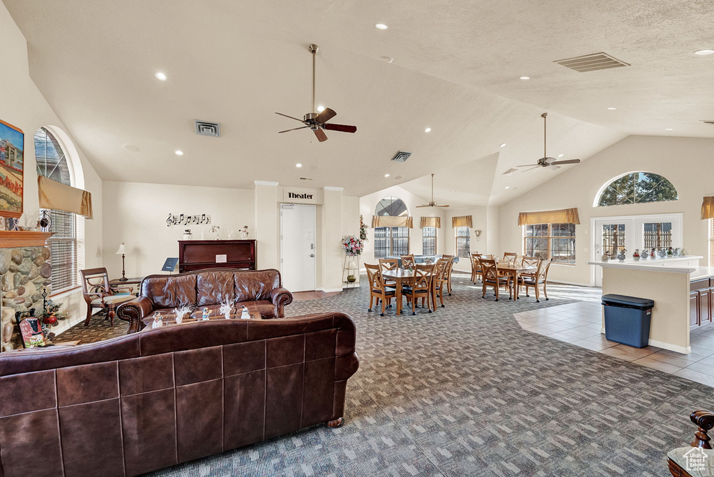 Living room with a ceiling fan, high vaulted ceiling, carpet, and recessed lighting