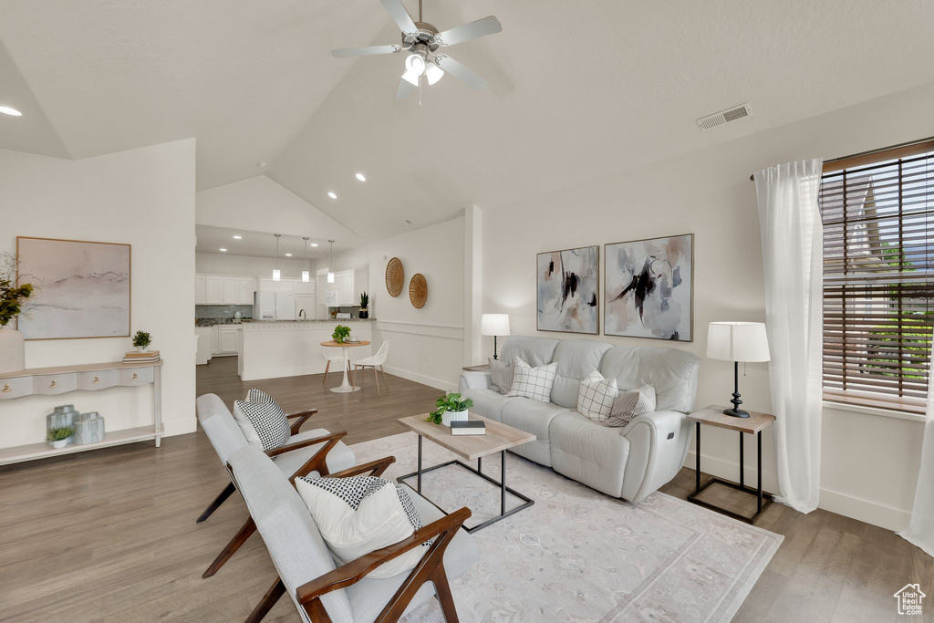 Living area with ceiling fan, lofted ceiling, light wood-style floors, recessed lighting, and baseboards