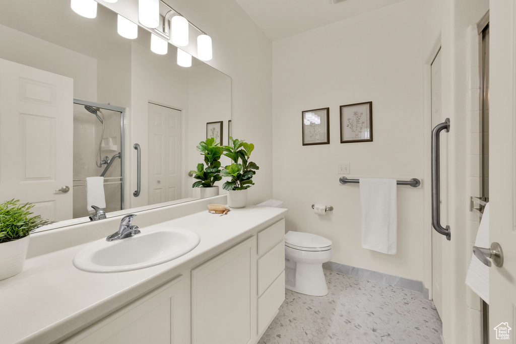 Full bath featuring vanity, a stall shower, and toilet