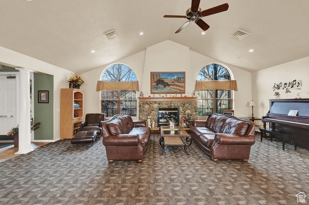 Living room with ornate columns, carpet flooring, high vaulted ceiling, a ceiling fan, and a fireplace