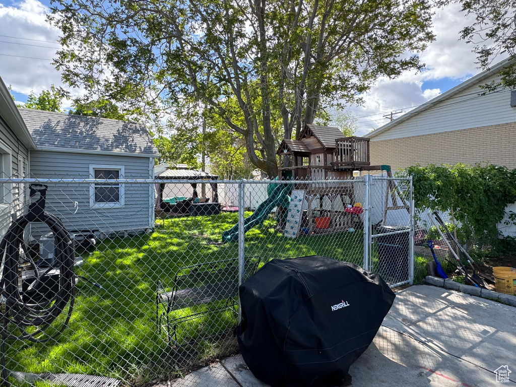 View of yard with a playground and a gate