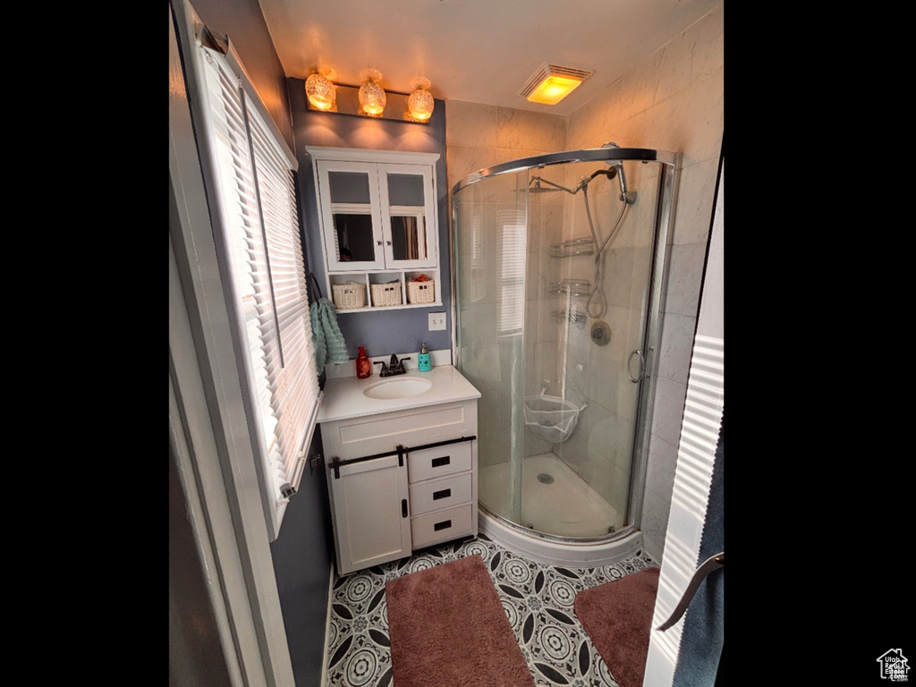 Full bathroom featuring vanity, a shower stall, and tile patterned flooring