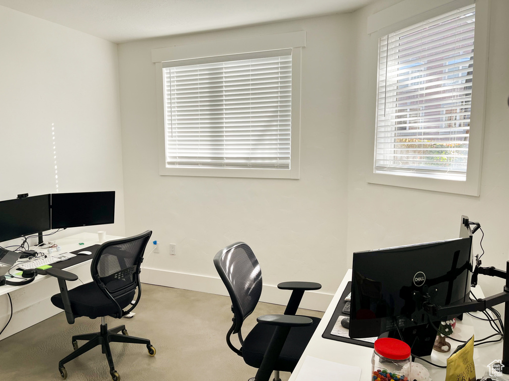 Carpeted office with plenty of natural light and baseboards