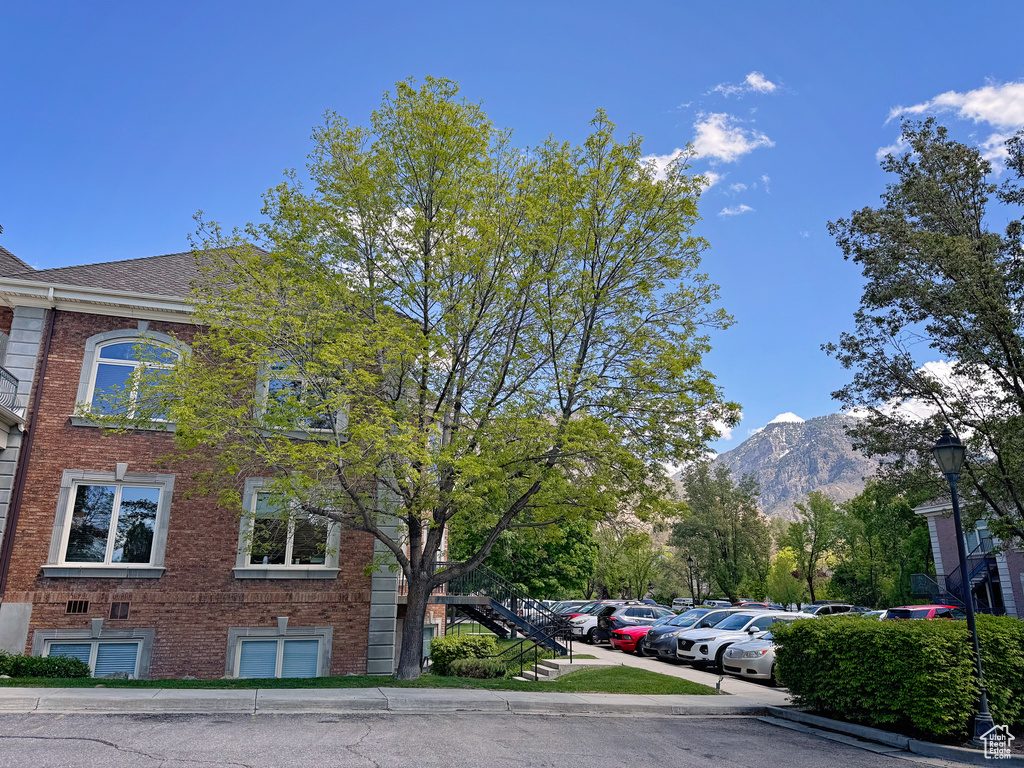 View of building exterior with uncovered parking, stairway, and a mountain view