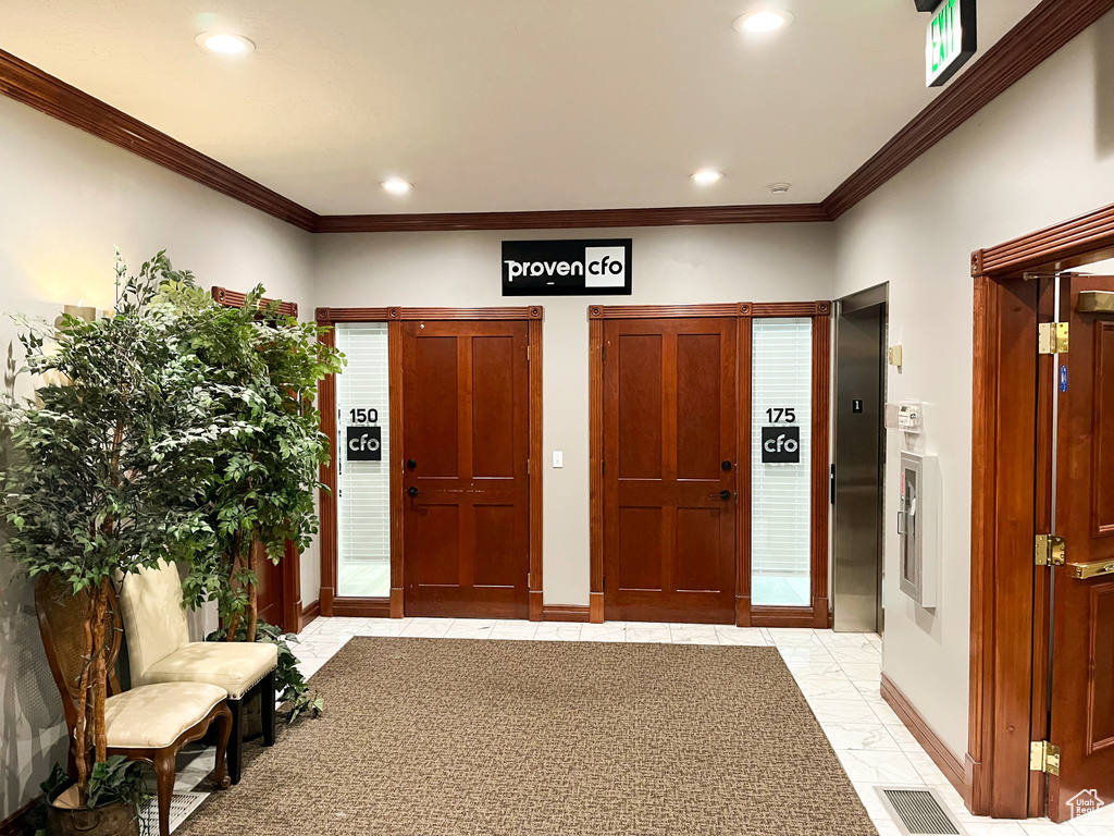 Entryway featuring baseboards, ornamental molding, recessed lighting, and elevator