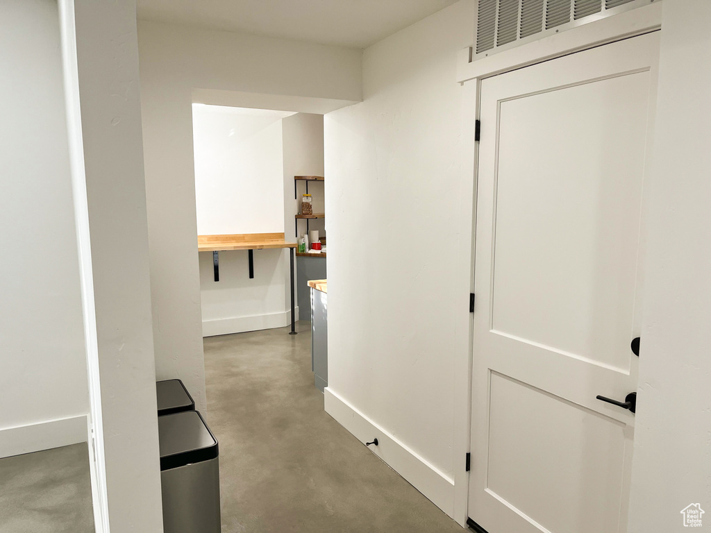 Hall featuring concrete floors and baseboards