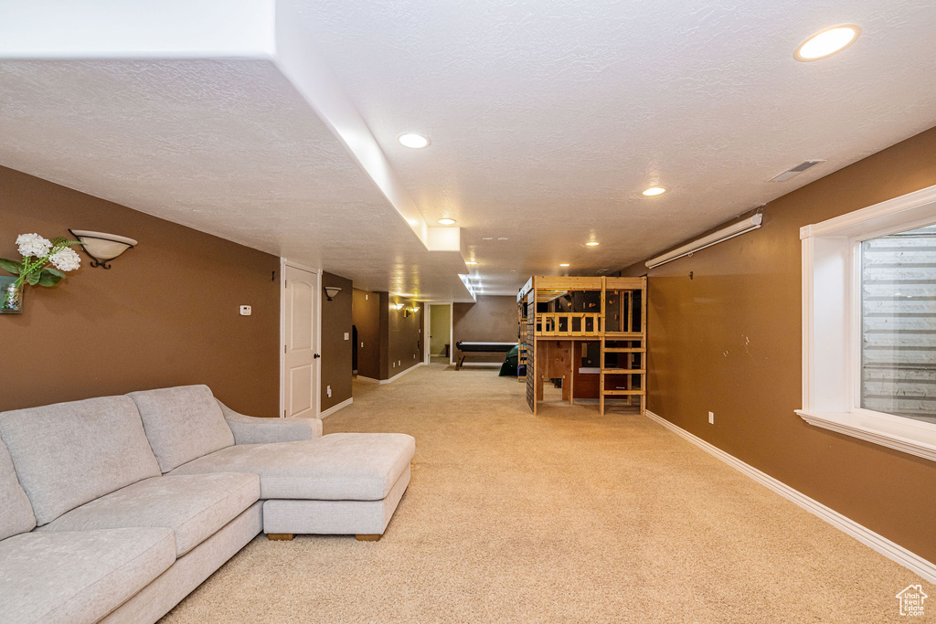 Living room featuring baseboards, carpet, recessed lighting, and a textured ceiling