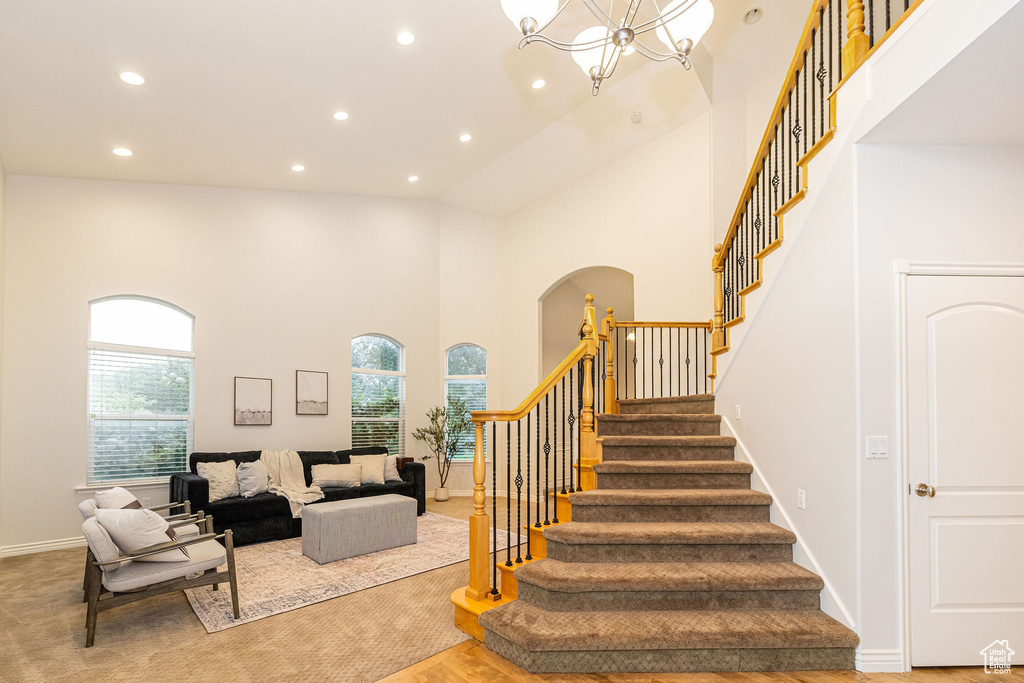Stairs featuring recessed lighting, a high ceiling, baseboards, a chandelier, and arched walkways