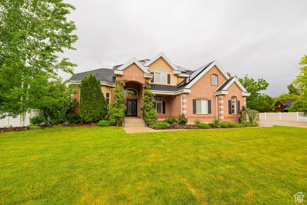 Traditional-style home featuring brick siding and roof mounted solar panels