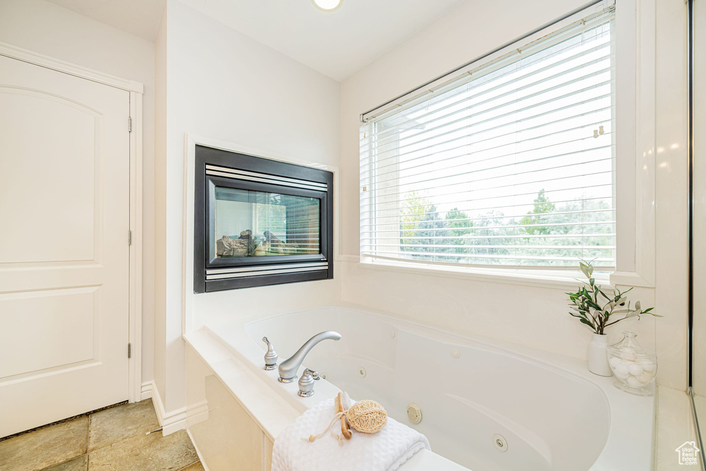 Full bath with a tub with jets and baseboards