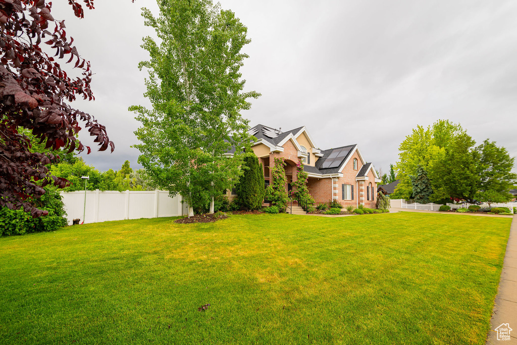 View of front of property with brick siding and solar panels