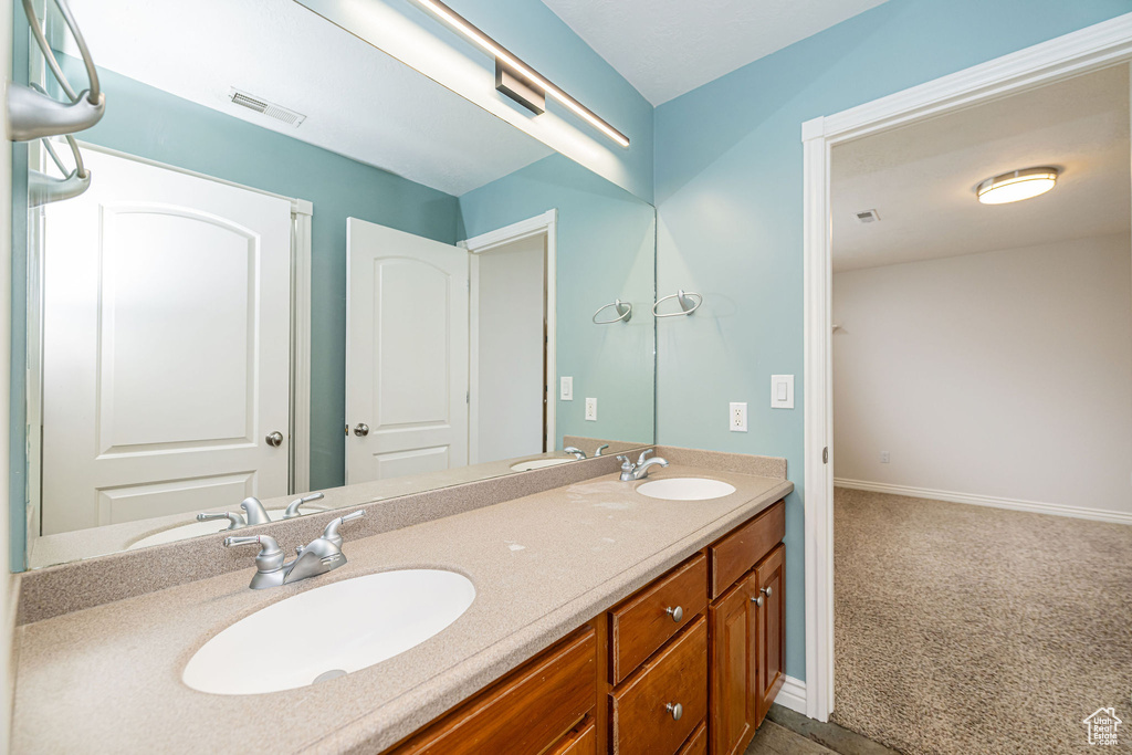 Full bathroom featuring double vanity and baseboards