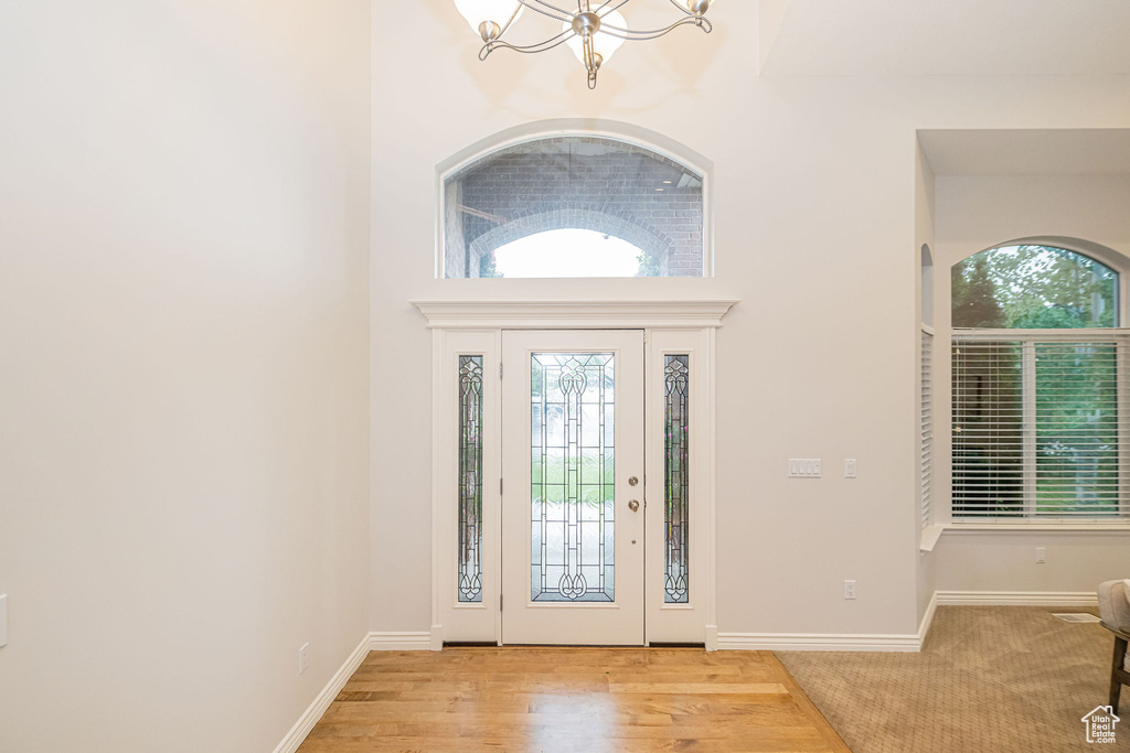 Foyer with a chandelier and baseboards
