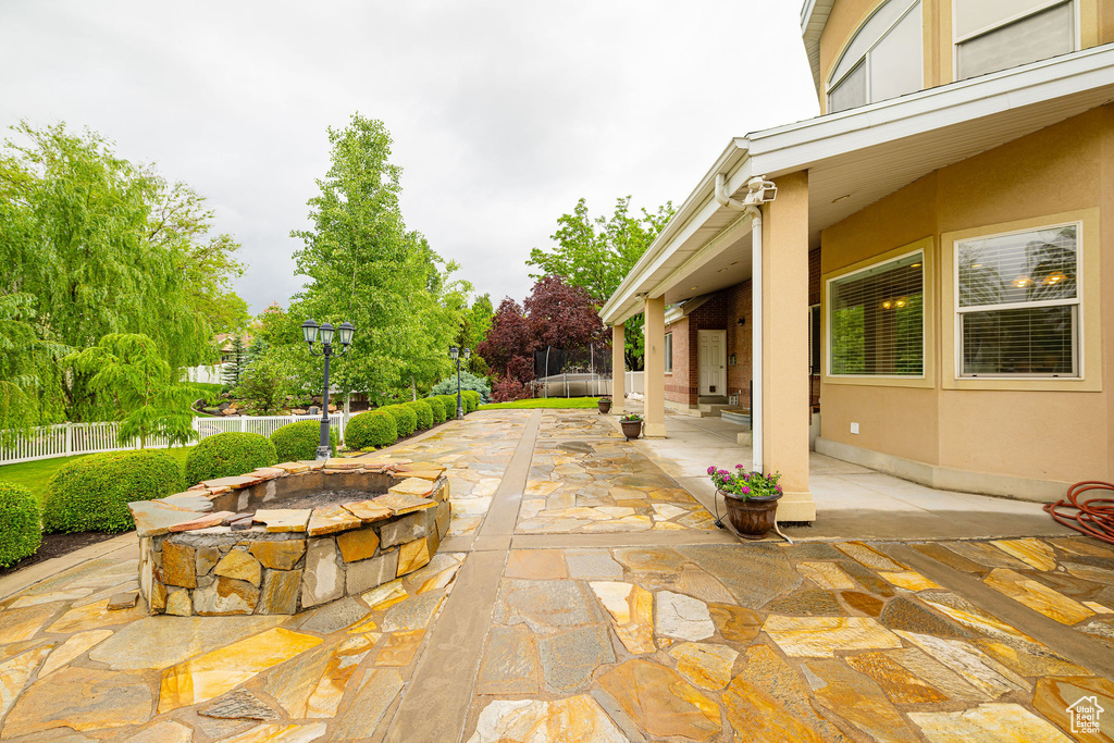 View of patio with a fire pit and a fenced backyard