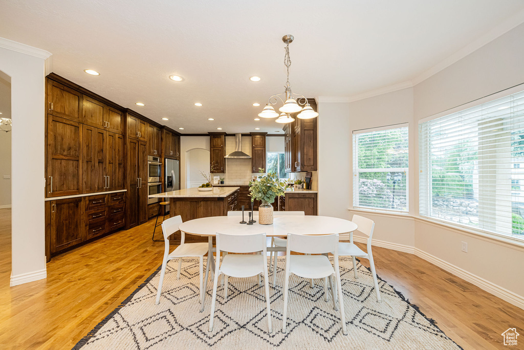 Dining room with ornamental molding, healthy amount of natural light, recessed lighting, baseboards, and light wood-style floors