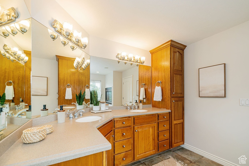 Full bath featuring baseboards and double vanity