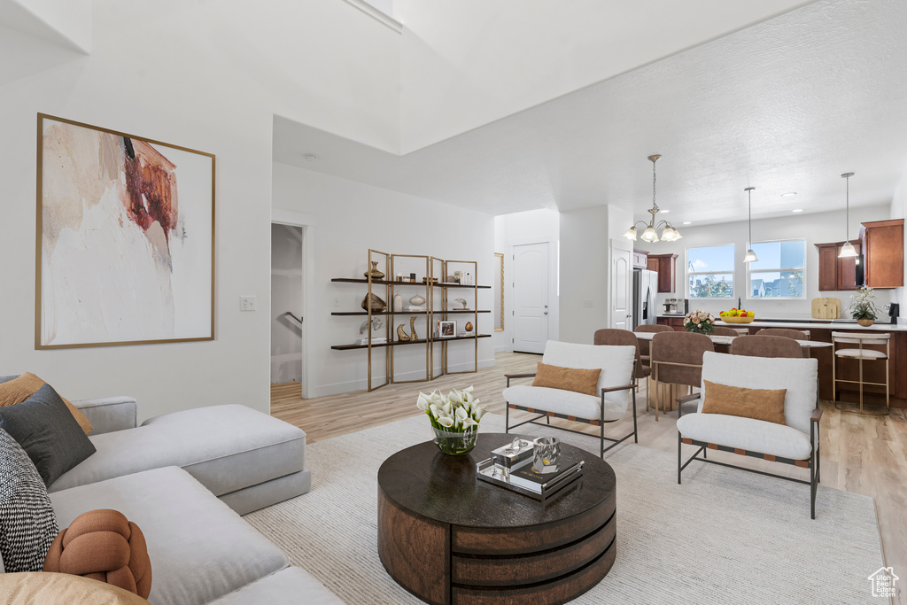 Living room featuring light wood-style floors and a chandelier