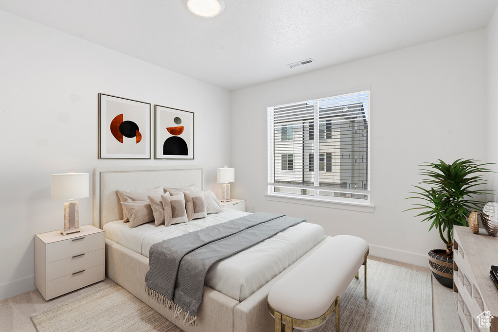 Bedroom with baseboards and light colored carpet
