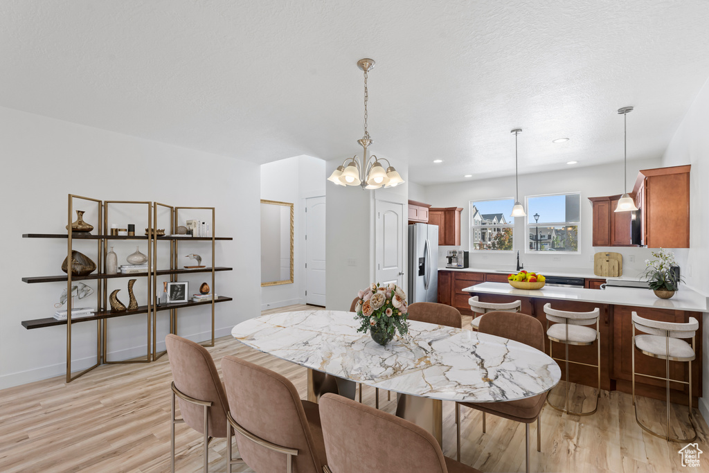 Dining space featuring a chandelier, light wood-style flooring, baseboards, and recessed lighting